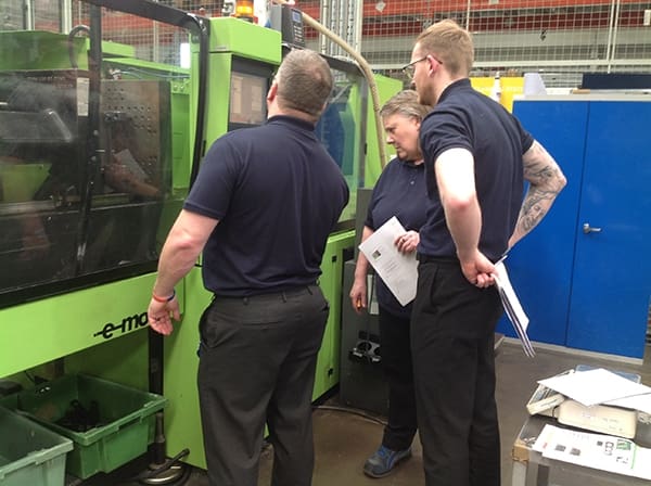 Advanced Plastics team surrounding injection moulding machine