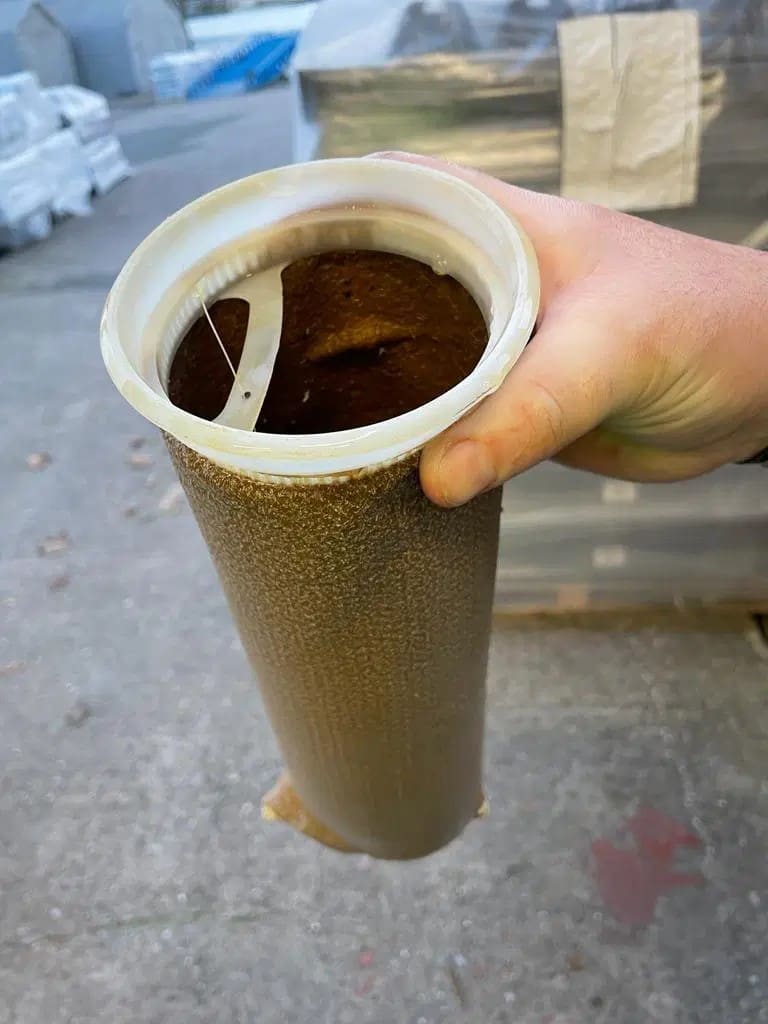 Heavily contaminated water filter cartridge filled with brown sludge.