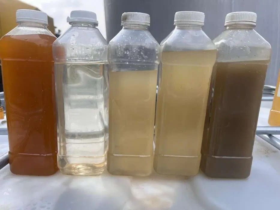Five transparent bottles showing different water samples ranging from clear to heavily contaminated.
