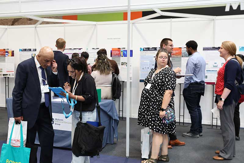 Attendees viewing and discussing research posters at The Advanced Materials Show.