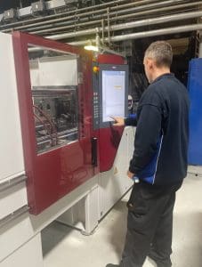 A Linear Plastics engineer working with a Wittmann machine.