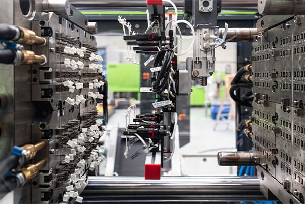Open 128-cavity injection mould with white connector components in the WINTEC e-win 1800.